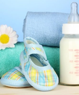 baby-bottle-milk-with-babys-bootees-near-towels-blue-background_392895-728922